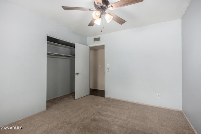 unfurnished bedroom with a closet, carpet flooring, visible vents, and a ceiling fan