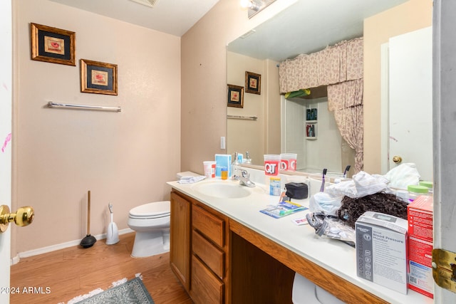 bathroom featuring toilet, hardwood / wood-style floors, and vanity