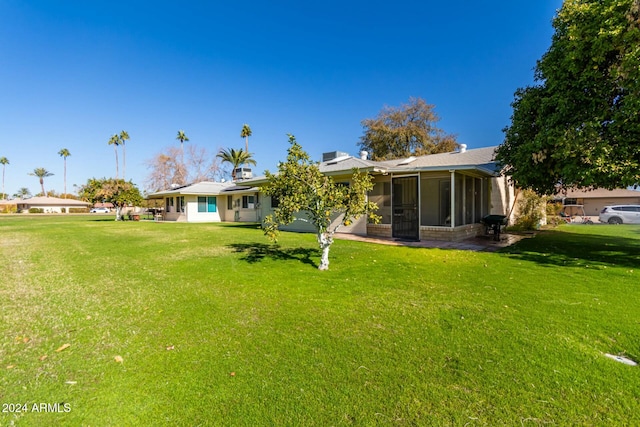 back of property with a yard and a sunroom