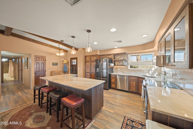 kitchen featuring sink, hanging light fixtures, stainless steel appliances, and hardwood / wood-style flooring