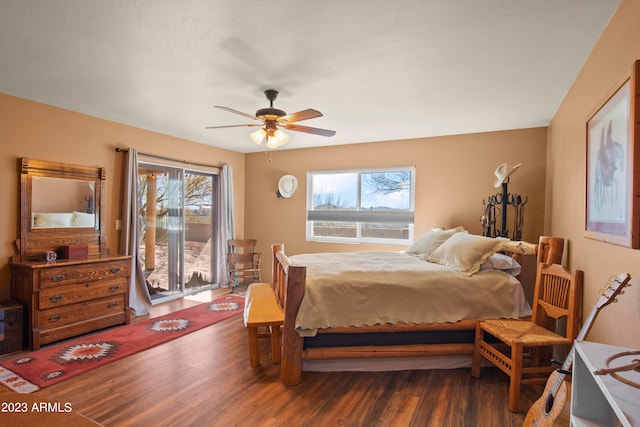 bedroom featuring dark hardwood / wood-style floors, ceiling fan, access to exterior, and multiple windows