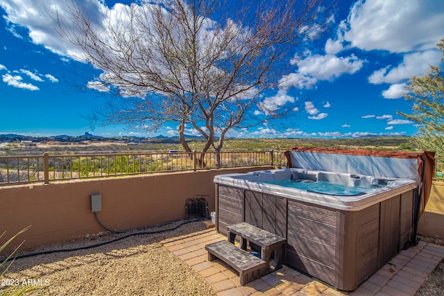 view of patio / terrace with a mountain view and a hot tub