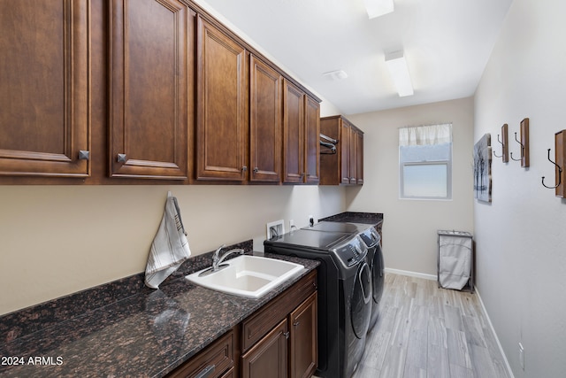 washroom featuring cabinets, light wood-type flooring, sink, and washing machine and dryer