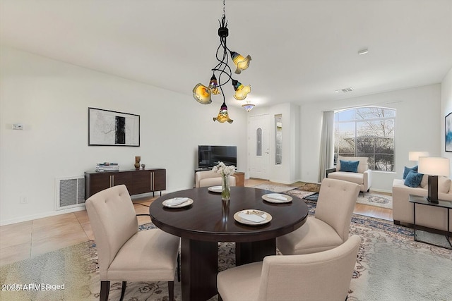 dining room with light tile patterned floors, baseboards, visible vents, and an inviting chandelier