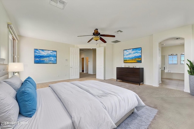 bedroom with baseboards, visible vents, and arched walkways