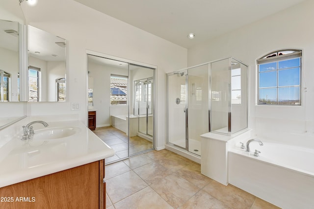 bathroom with a stall shower, a healthy amount of sunlight, vanity, and a bath