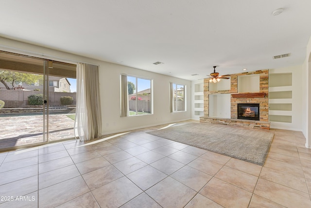 unfurnished living room featuring built in shelves, visible vents, and light tile patterned floors