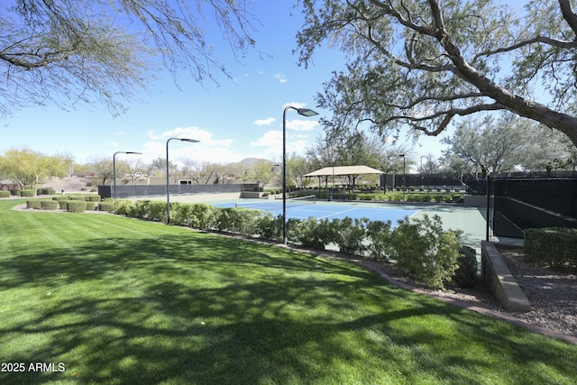 view of yard featuring community basketball court and fence