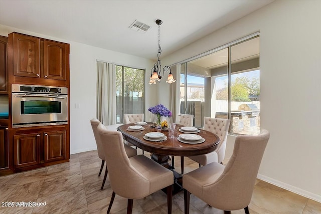 dining area featuring baseboards, visible vents, and a chandelier