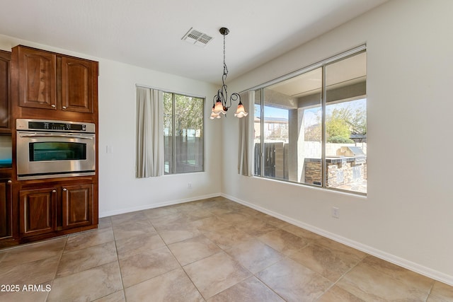 unfurnished dining area featuring visible vents, a notable chandelier, and baseboards