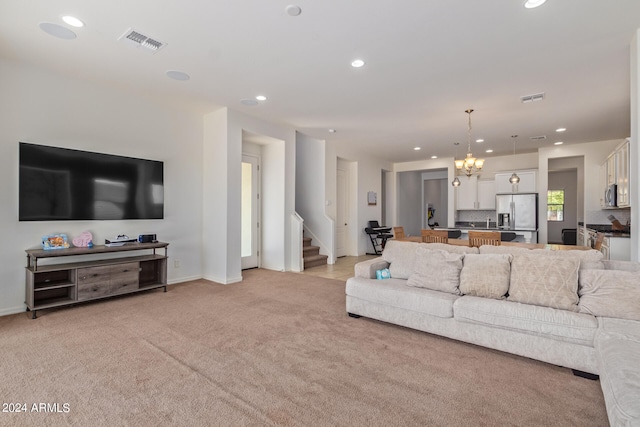 carpeted living room with a notable chandelier