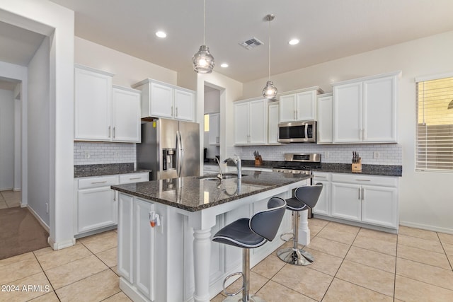 kitchen with white cabinetry, appliances with stainless steel finishes, sink, and an island with sink