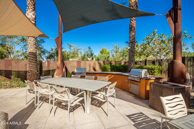 view of patio with an outdoor kitchen and a grill