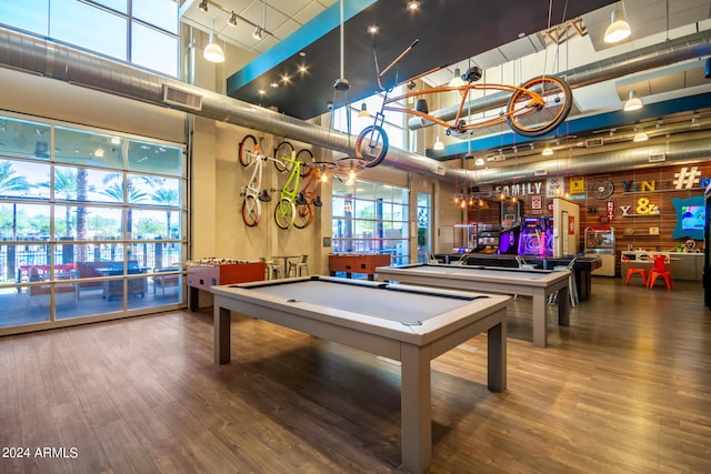 playroom with pool table, indoor bar, wood-type flooring, and a towering ceiling