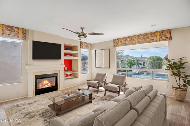 living room featuring built in shelves and ceiling fan