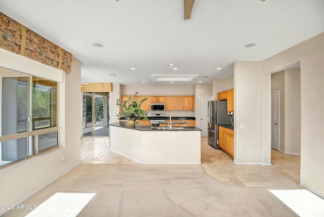 kitchen featuring a kitchen island with sink, sink, and stainless steel appliances