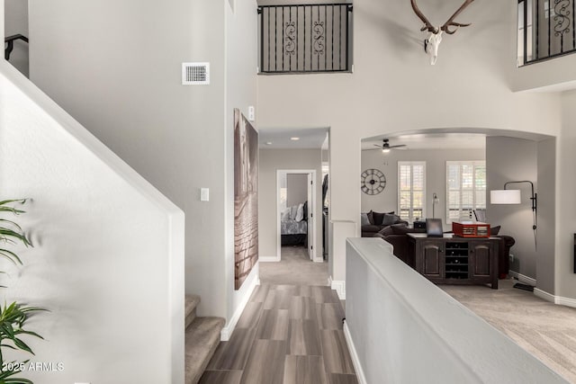 corridor featuring a high ceiling and hardwood / wood-style flooring