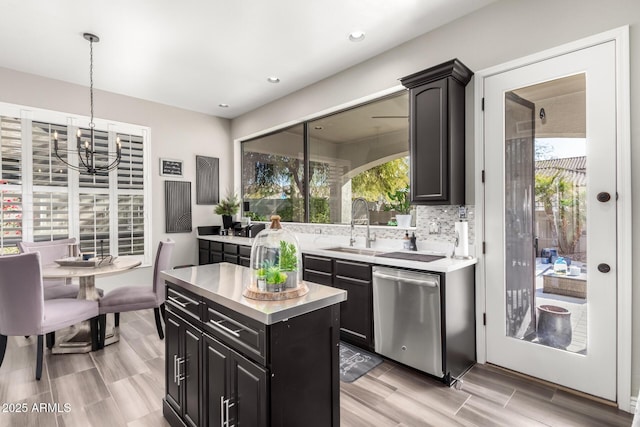 kitchen featuring sink, dishwasher, hanging light fixtures, a center island, and decorative backsplash