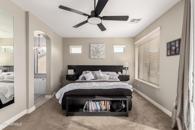 carpeted bedroom featuring ceiling fan with notable chandelier