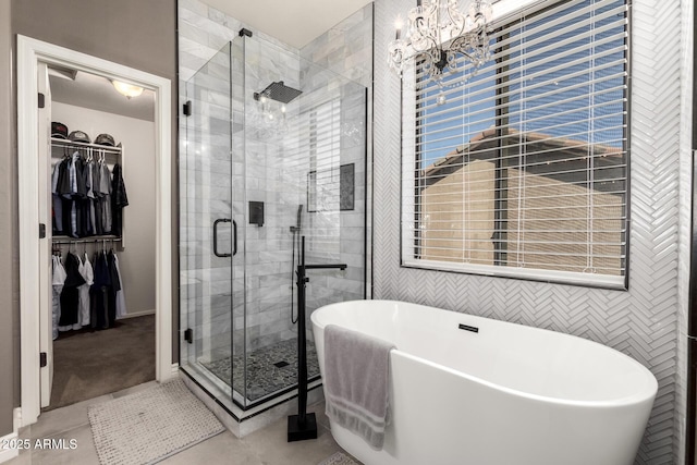 bathroom featuring plus walk in shower, a chandelier, and tile patterned flooring