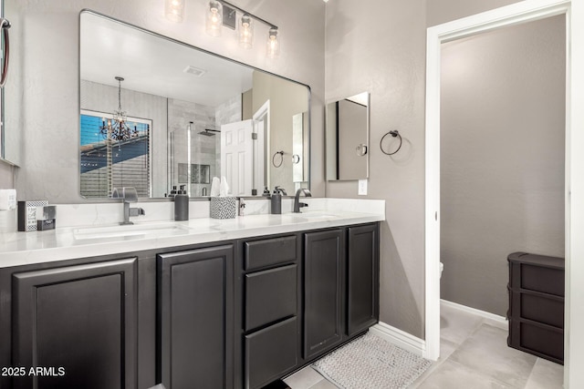 bathroom with a chandelier, vanity, a shower with shower door, and tile patterned flooring