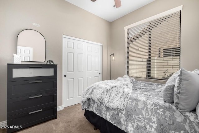 carpeted bedroom featuring ceiling fan and a closet