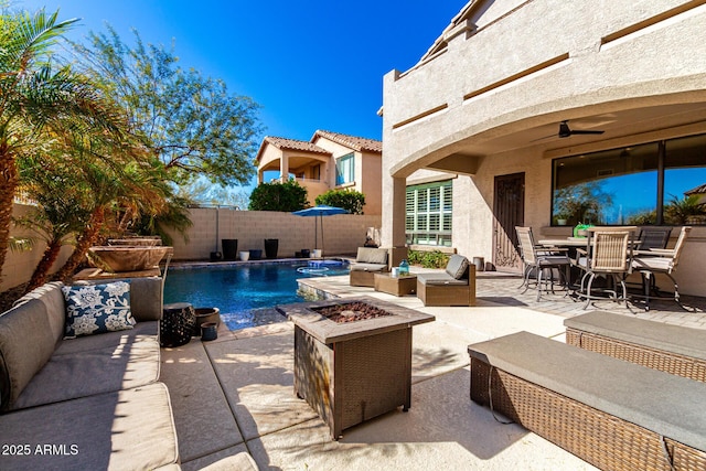 view of swimming pool featuring an outdoor living space with a fire pit, a patio, and ceiling fan