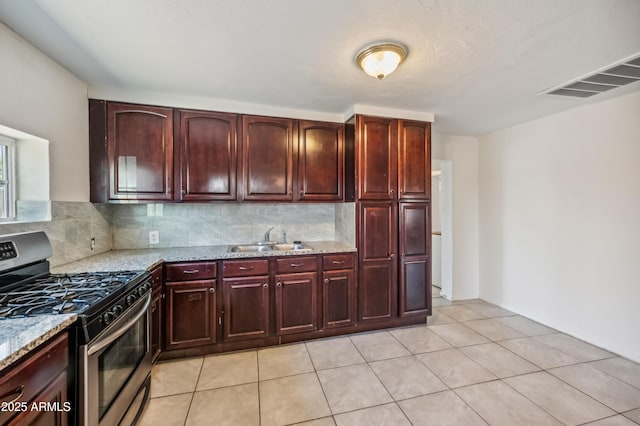 4441 S 8th St, Phoenix, AZ 85040 - kitchen with gas range, decorative backsplash, light stone counters, and a sink