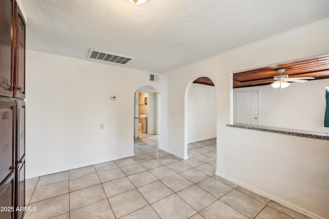 4441 S 8th St, Phoenix, AZ 85040 - spare room with arched walkways, a ceiling fan, and light tile patterned floors