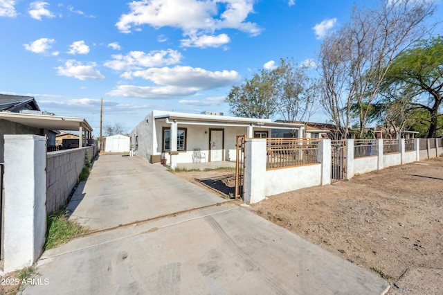 4441 S 8th St, Phoenix, AZ 85040 - view of front of home featuring driveway, a fenced front yard, stucco siding, a gate, and a shed