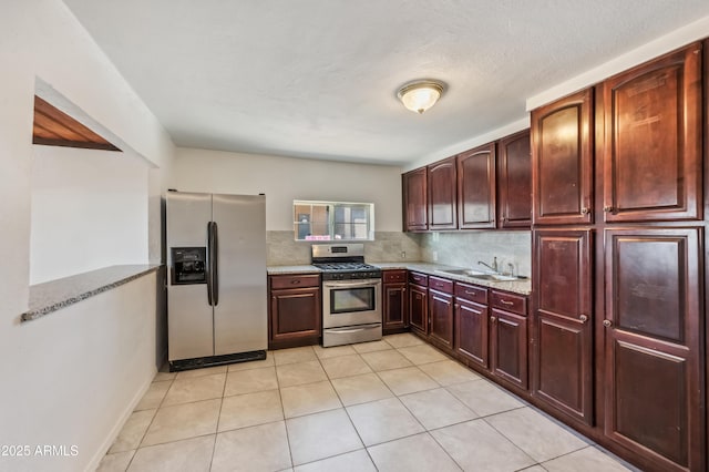 4441 S 8th St, Phoenix, AZ 85040 - kitchen featuring stainless steel appliances, decorative backsplash, a sink, reddish brown cabinets, and light tile patterned floors