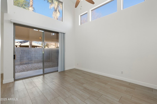 spare room with ceiling fan and a towering ceiling