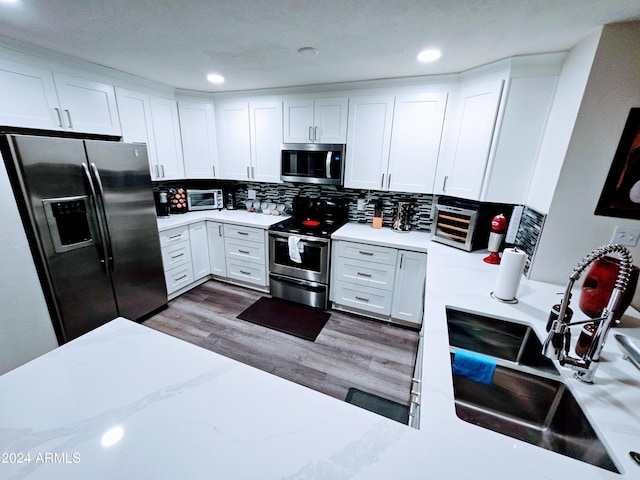 1801 N 87th Pl, Scottsdale, AZ 85257 - kitchen featuring stainless steel appliances, white cabinetry, wood finished floors, tasteful backsplash, and light stone countertops