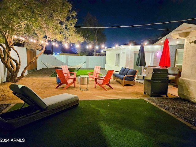1801 N 87th Pl, Scottsdale, AZ 85257 - patio at night with a grill, a fenced backyard, a patio area, and an outdoor hangout area