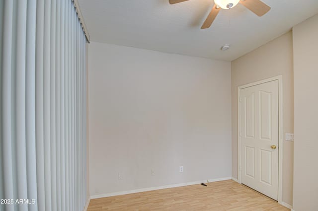 spare room with light wood-style flooring, baseboards, and ceiling fan