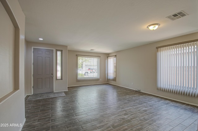 foyer featuring recessed lighting, visible vents, baseboards, and dark wood-style flooring