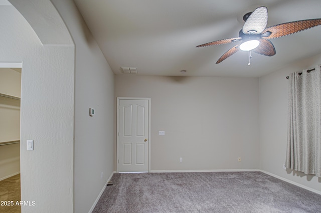 empty room with baseboards, carpet, visible vents, and ceiling fan