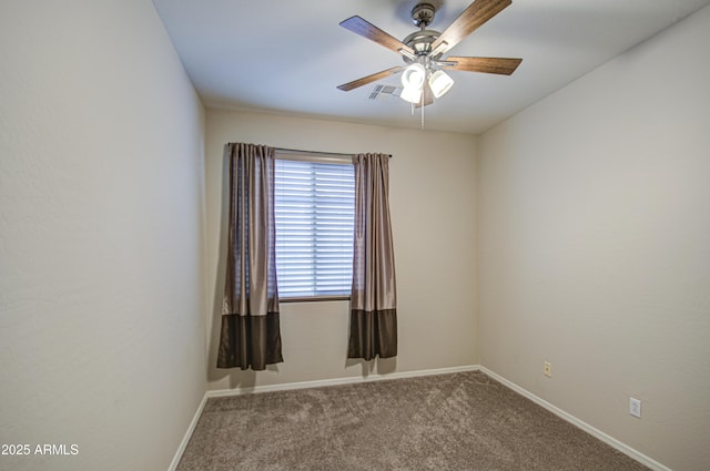 carpeted spare room with visible vents, baseboards, and ceiling fan