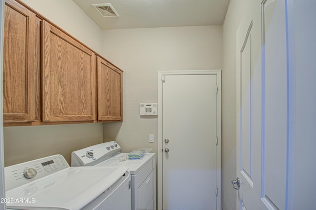 laundry room with visible vents, cabinet space, and separate washer and dryer