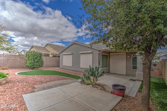 view of front of house featuring a patio area, stucco siding, a tiled roof, and a fenced backyard