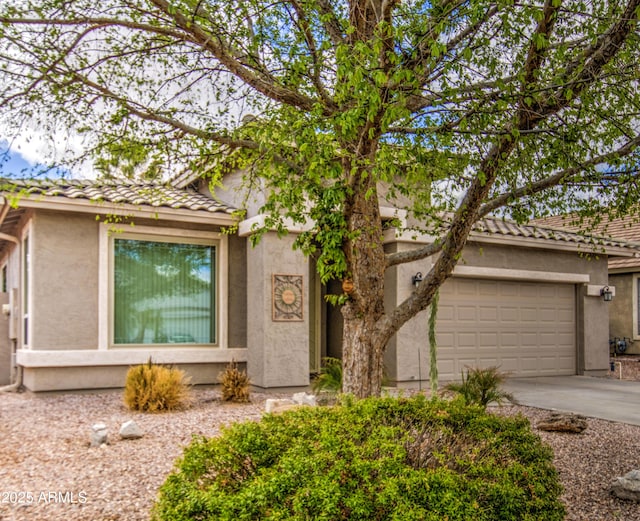 view of front of property with stucco siding, an attached garage, and concrete driveway