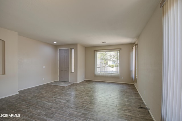 spare room featuring visible vents, baseboards, and wood tiled floor