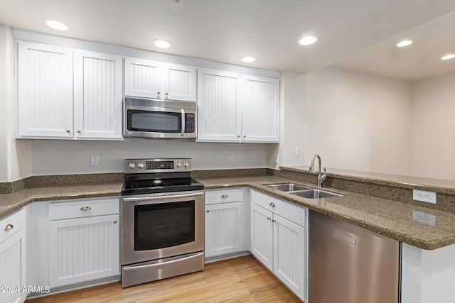 kitchen with sink, white cabinetry, light hardwood / wood-style flooring, and stainless steel appliances