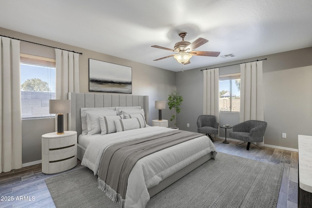 bedroom featuring multiple windows, dark hardwood / wood-style flooring, and ceiling fan