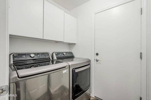 clothes washing area with separate washer and dryer and cabinets