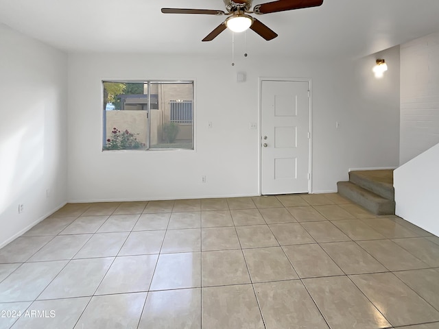 tiled spare room with ceiling fan