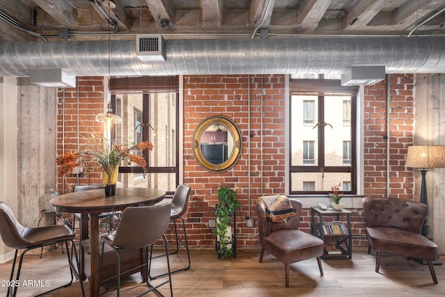 sitting room featuring hardwood / wood-style floors and brick wall