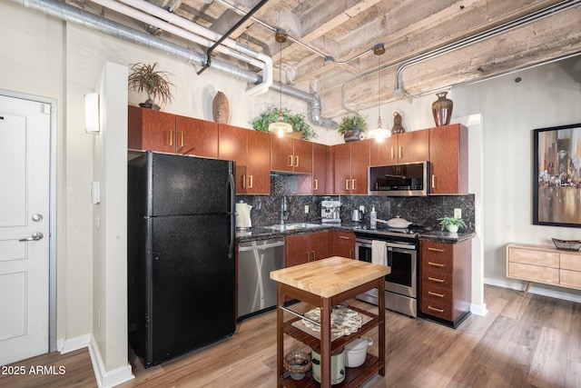 kitchen featuring appliances with stainless steel finishes, sink, and light hardwood / wood-style flooring