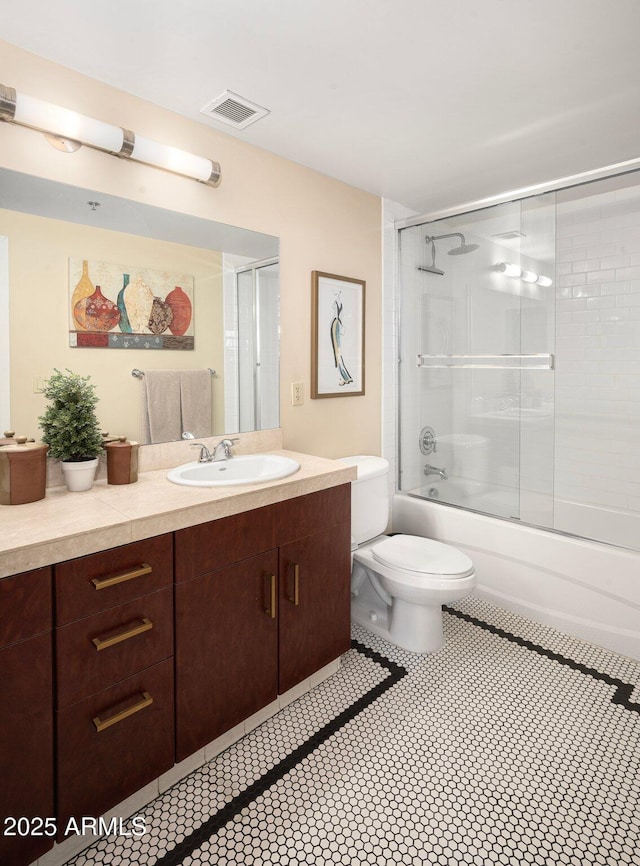 full bathroom with vanity, combined bath / shower with glass door, and toilet