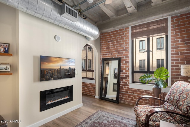 living room with light wood-type flooring and brick wall